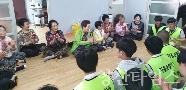 양산고 학생들이 마을 어르신들께 카네이션을 달아드리고 있다. ⓒ양산타임스