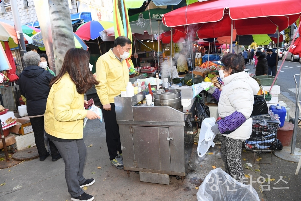 ▲ 11월 30일 오전 11시경 기장군 직원들이 기장읍 기장시장 주변 난전상, 노점상 상인들에게 손소독제와 코로나19방역수칙 안내문을 나눠주고 마스크착용, 손소독제 사용 등 방역수칙을 준수해 줄 것을 요청하고 있다. ⓒ양산타임스