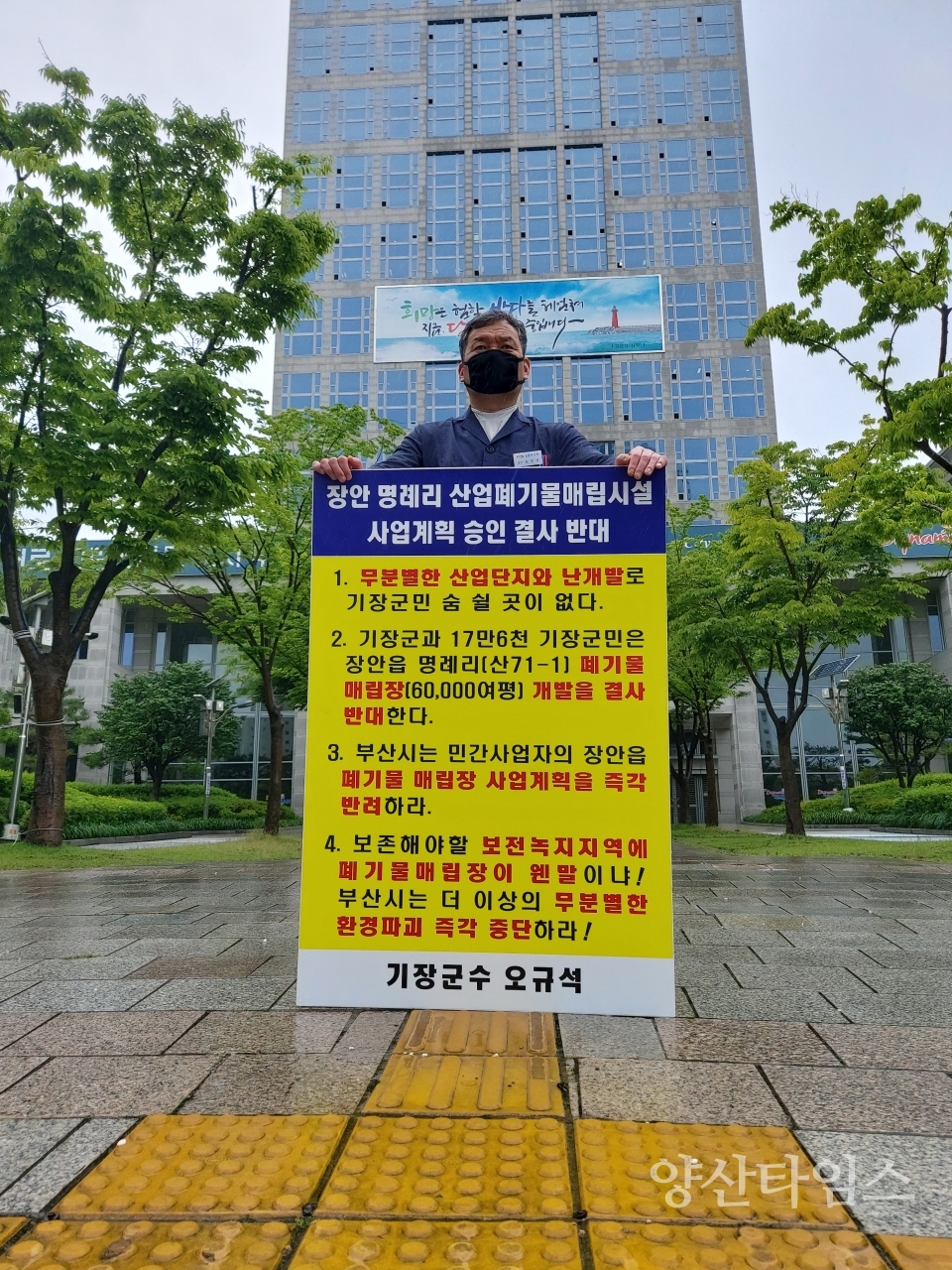 "토요일인 12일 오전11시 기장군수가 부산시청 앞에서 장안읍 명례리 산업폐기물 매립시설 사업계획 승인 결사반대를 외치며 빗속에서 1인 시위 중이다."ⓒ양산타임스