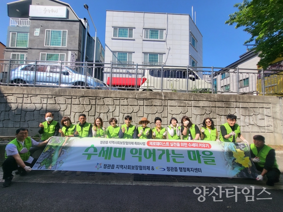 정관읍지역사회보장협의체 위원들이 수세미 모종심기 행사를 진행하고 기념촬영을 하고 있다ⓒ양산타임스