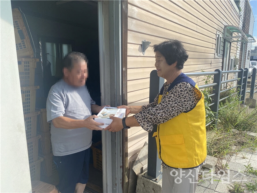 최귀하 장안읍 지역사회보장협의체 위원장이 대상자에게 건강물품(온열찜질기)를 전달하고 있다ⓒ양산타임스