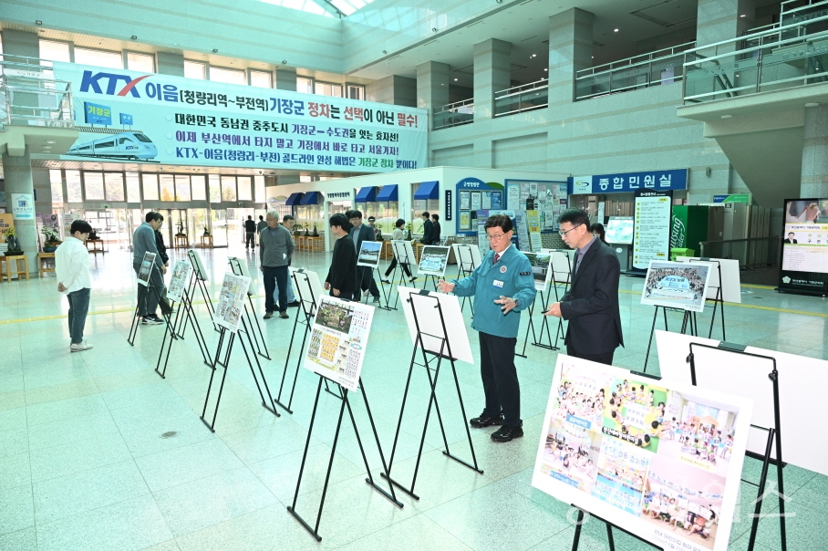 정종복 기장군수와 주민들이 KTX-이음 정차역 유치기원 사진전을 둘러보고 있다ⓒ양산타임스