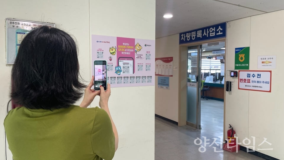 차량등록 민원서식을 QR코드로 확인할 수 있도록 제작한 홍보물과 핸드폰으로 서비스를 이용하는 모습ⓒ양산타임스